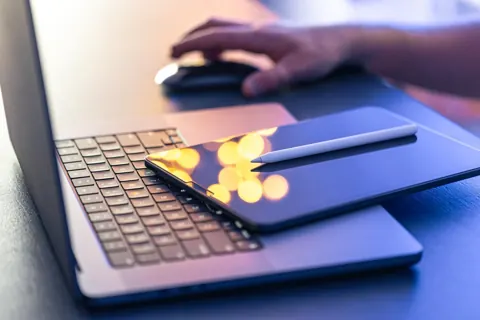 Reviewing documents beside a laptop
